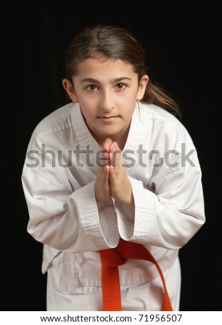 stock photo Pretty preteen girl in karate uniform bowing