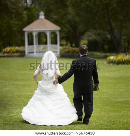 Bride and groom walking away outside wedding ceremony