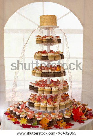 Wedding cake of cupcakes with autumn leaves at reception