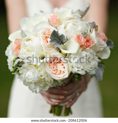 Wedding bouquet in hands of bride closeup