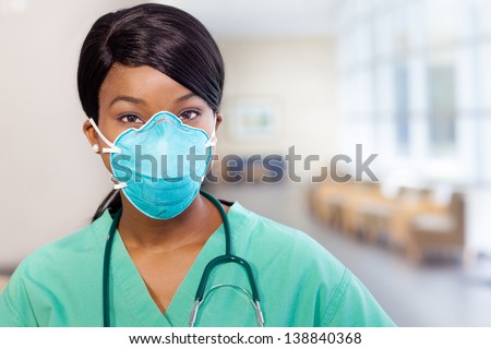 African American nurse at hospital with mask covering her mouth and stethoscope.