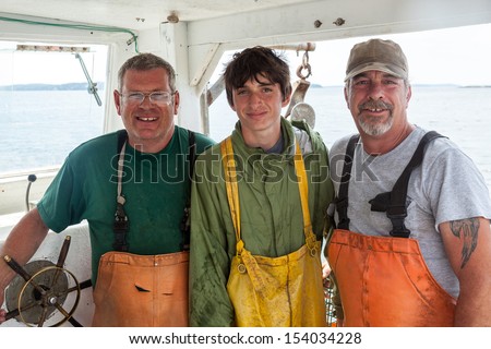 Portrait of three caucasian lobster-men in boat, Maine, USA