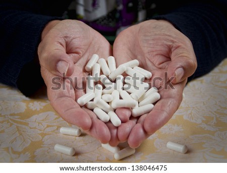 Taking pills. Close up of a white pills in woman\'s hands.