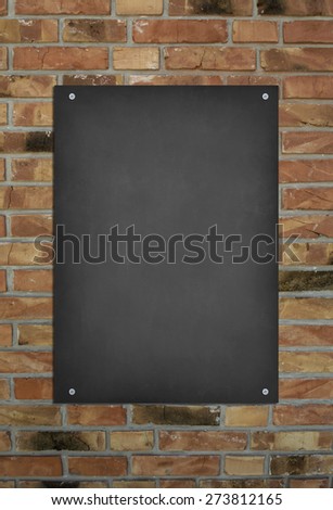 Blank blackboard at a brick wall background with space for text