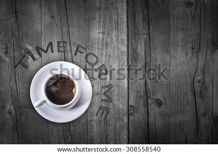Coffee cup with text ``Time for me`` design by letterpress on wooden background