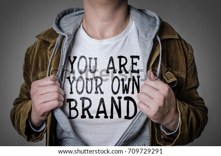 Man showing You Are Your Own Brand tittle on t-shirt. Personal branding concept.
