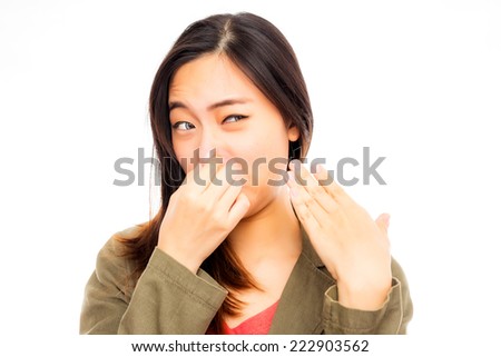 young asian woman annoyed by a bad smell
