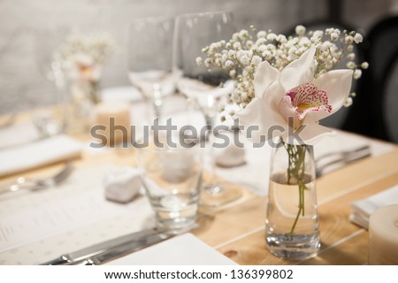 Color image. Birthday reception table setting with flowers and candles with flame. Shooting in poor conditions with high ISO. Developed from RAW; retouched with special care and attention;