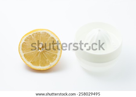 Lemon squeezer and a whole lemon on white background