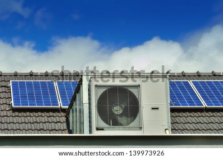 Heat Pump and Solar Panels on a Family House Roof