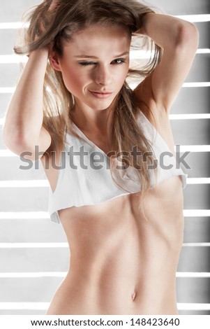 young athletic girl in a short t-shirt winks