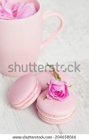 Gentle pink macaroons with rose on wood, pastel colored, selective focus