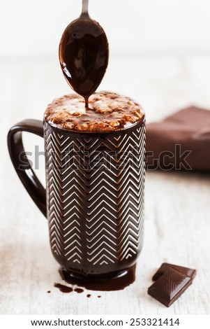 Cup of coffee with whipped cream and melted chocolate on white background