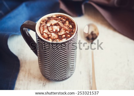 Cup of coffee with whipped cream and melted chocolate on white background with towel