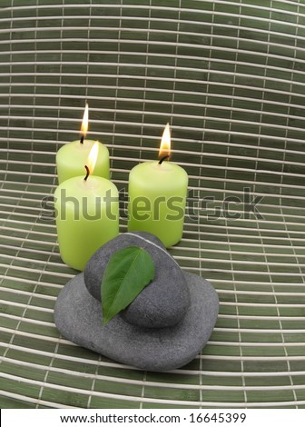 green candles with stones and leaf