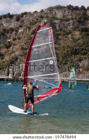 TORBOLE SUL GARDA, ITALY - AUG 30, 2009: People windsurfing in the northern tip of the Lake Garda, that, thanks to the constant wind, is the ideal place for windsurfing, kite surfing and sailing.