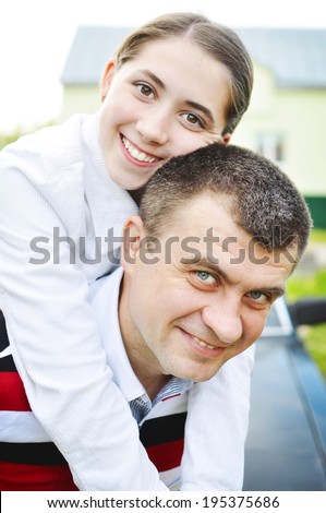 Happy dad with teenage daughter. Happy father with teenage daughter on the background of their car and house.