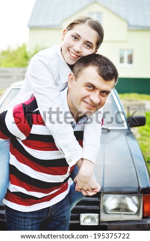 Happy dad with teenage daughter. Happy father with teenage daughter on the background of their car and house.