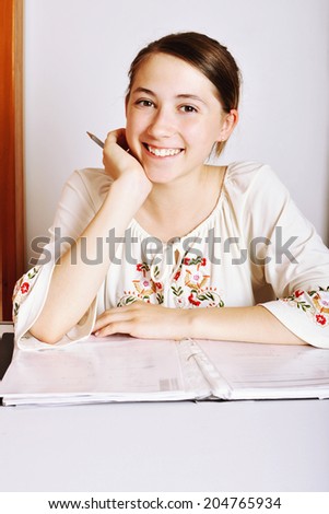College student studying. Studying cheerful  teenager girl reading her book for school.
