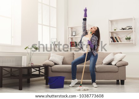 Happy woman cleaning home, dancing with mop and having fun, copy space. Housework, chores concept