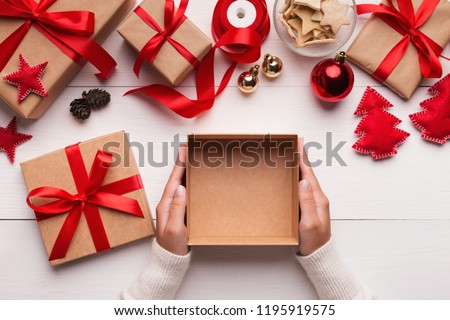Best Christmas gift. Woman hands holding empty craft gift box, preparing surprise for holiday, top view, copy space