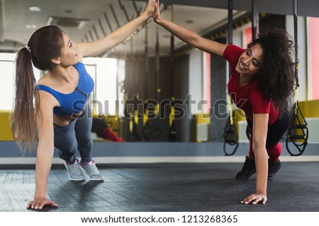 High five at gym, fitness girls doing push ups during workout