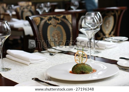 Vegetarian creative food in luxurious restaurant interior, served table