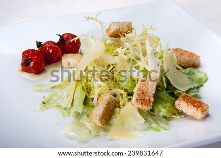 Caesar salad served with dried cherry tomatoes closeup in the restaurant