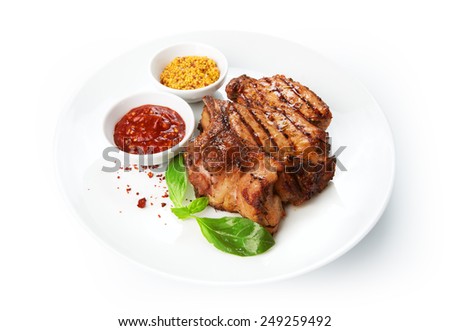 Restaurant food - grilled pork chops with sauces isolated at the white background