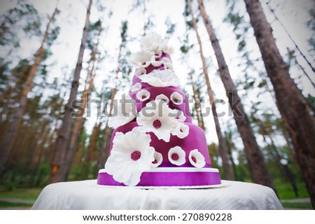 Grand violet wedding cake with white sugar paste flowers