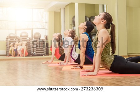 Group of women making yoga stretching in the fitness class, healthy lifestyle concept