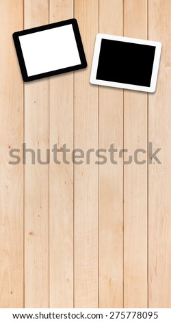 Black and white tablets PC with white and black screens on a light wooden table