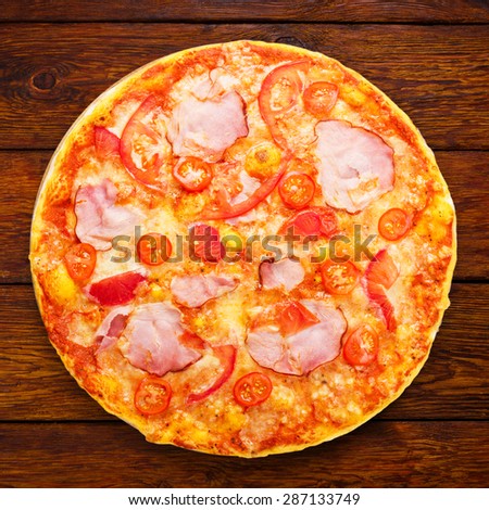 Delicious pizza with peppers, bacon and cherry tomatoes - thin pastry crust isolated at white background, above view
