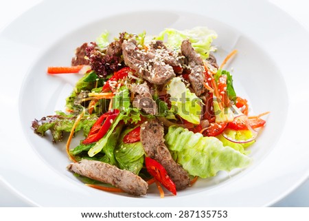 Restaurant food - meat salad with roasted beef, pepper, lettuce and other vegetables