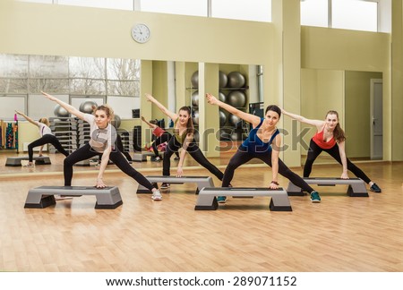 Group of women making step aerobics in the fitness class