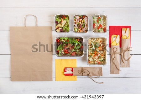 Healthy food delivery. Take away of natural organic low carb. Eat right concept, healthy food, fitness nutrition take away in aluminium boxes, cutlery and package, top view, flat lay at white wood