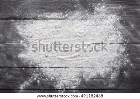 Baking class or recipe concept on dark background, sprinkled wheat flour with free text copy space. Baking preparation, top view on wooden board or table. Cooking dough or pastry.