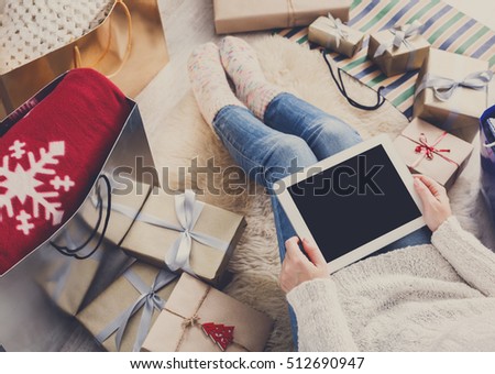 Christmas online shopping above view. Female buyer make internet order at screen of tablet. Woman buy presents prepare to xmas eve, among gift boxes and packages. Winter holidays sale