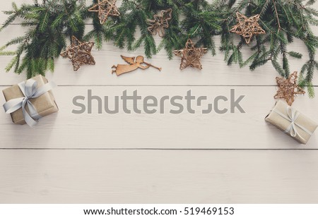 Christmas decoration, gift boxes and garland frame concept background, top view with copy space on white wood table surface. Christmas ornaments and presents border