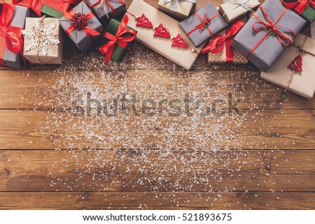 Christmas decoration, gift boxes and garland frame concept background, top view with copy space on wood table surface. Christmas ornaments and presents border with snow