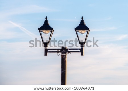 A vintage street lamp against an evening sky
