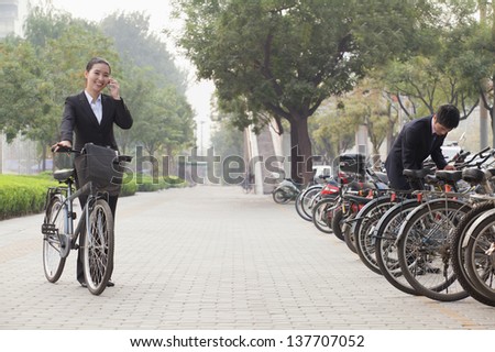 Young Business people parking their bikes and talking on the phone in Beijing