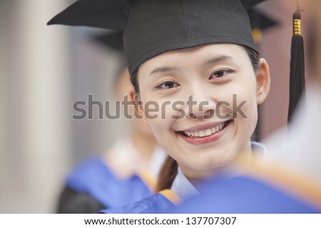 Close Up of Female Graduate Student Standing in a Row of Graduates