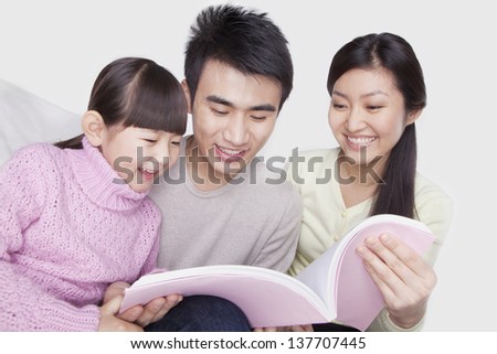 Family reading on the sofa, studio shot