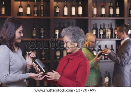 People Examining Wine Bottles, Two Women in the Foreground