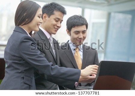 Three Business People Looking at Laptop