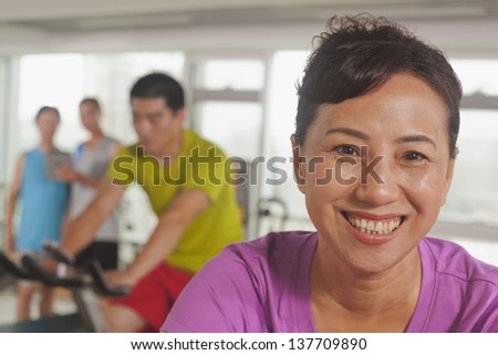 Woman smiling and exercising on the exercise bike