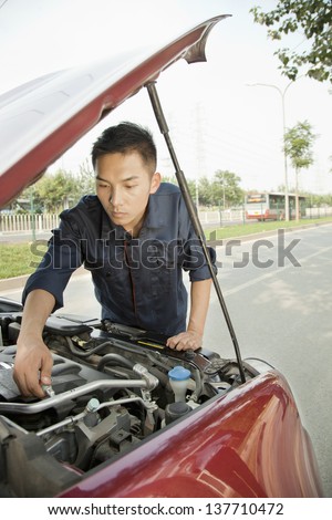Mechanic Fixing Car by Roadside