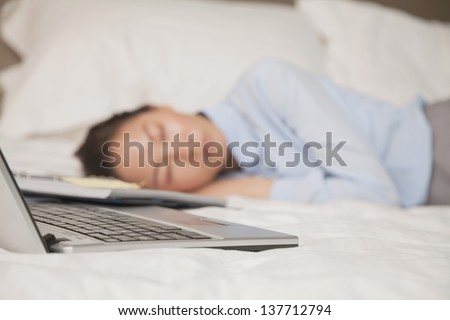 Overworked businesswoman in the bed with her laptop
