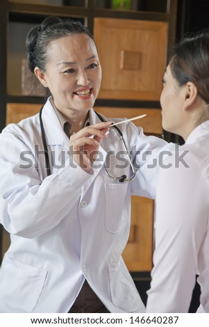 Doctor Using Tongue Depressor on Patient